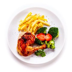 Grilled chicken leg with chips and vegetables on white background