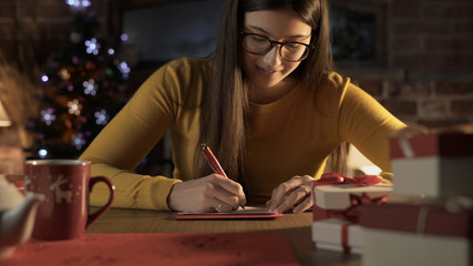 Woman writing wishes on a Christmas card