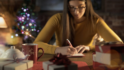 Woman writing wishes on a Christmas card
