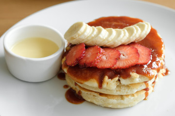 Delicious pancakes with strawberries, bananas and sauce. Cafe Breakfast Concept