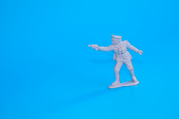 Fototapeta na wymiar small plastic soldiers standing on a blue background