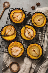 Pears and custard mini tarts on a dark gray concrete old table background. Top view.