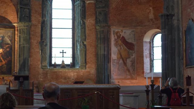 tourist walking and took picture of sacra san michele painting