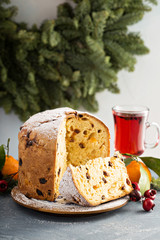 Traditional Christmas panettone with dried fruits and orange zest on light background