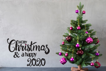 Fototapeta na wymiar Egnlish Calligraphy Merry Christmas And A Happy 2020. Tree With Purple Christmas Ball Ornament. Gray Concrete Background.