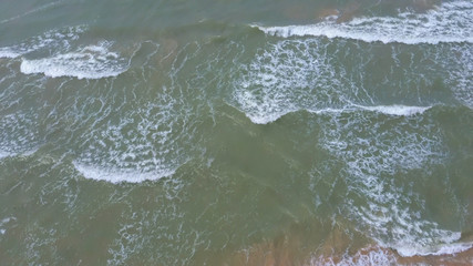 Naklejka premium Aerial Dron Shot of the Baltic Sea Costline With Waves View From Above. Sea Waves Over a Sandy Beach.top View of Sea Waves Foaming and Splashing, Big Waves From Above 