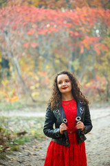 Beautiful girl with curls in the autumn park