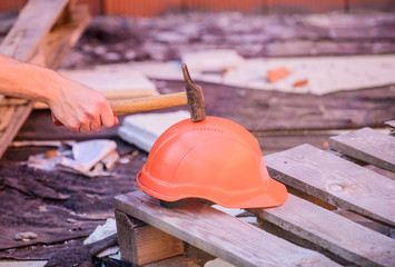 Material strength. Building construction. Professional hard hat. Engineer architect repairer safety accessory. Helmet or hard hat. Hammer knocking helmet close up. Test concept. Protective helmet