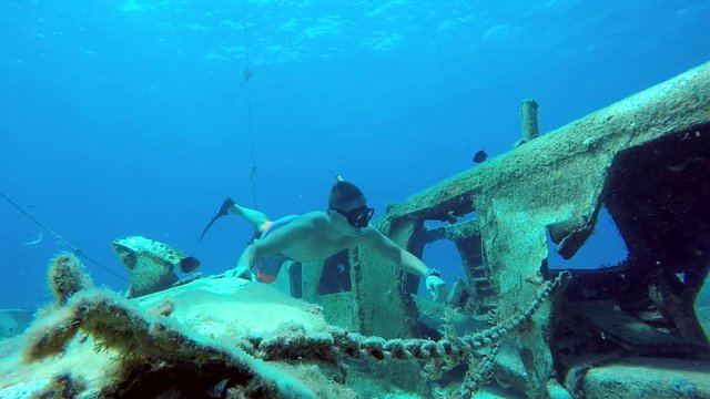freediver swimming around wrecked airplane