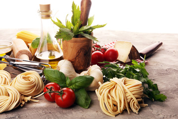 Pasta, vegetables, herbs and spices for Italian food on rustic table