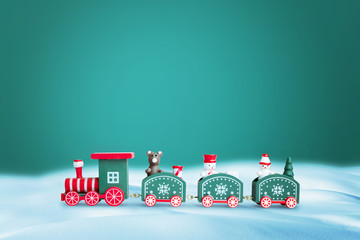 Green train in snow. Copy space above on green background for greeting text. Christmas, New Year greeting card concept.