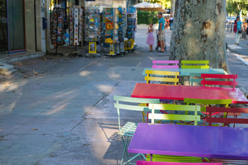  Documentary image. Editorial Illustrative. Arles. Provence. France. September 28.2019. Colored  empty tables and chairs on city street. Provence tourism.