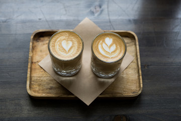 .Two cup of cappuccino art on a wooden table. Bokeh background.