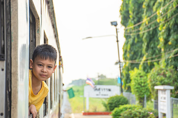 Portrait of asian boy on the train background window views and trees.