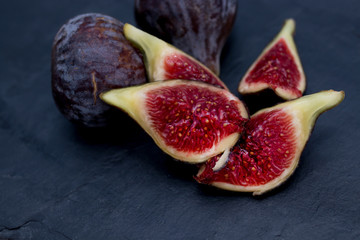 open natural black figs isolated on black background