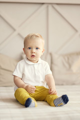 Naklejka premium little boy sitting on the bed