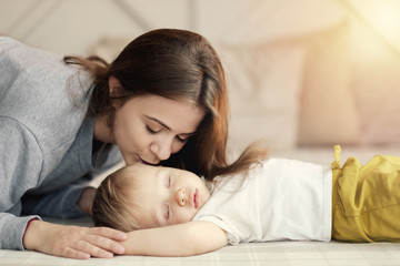 mother and child on bed, mum kiss her son, feelings, relationship of mother and child,