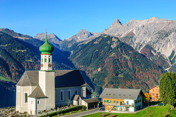 Fototapeta na wymiar Herbstliche Szenerie im Montafon mit barocker Kirche