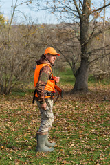 Hunting period, autumn season open. A hunter with a gun in his hands in hunting clothes in the...