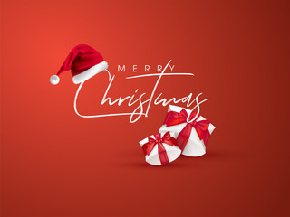 Calligraphy text Merry Christmas with santa hat and gift boxes on orange background can be used as greeting card design. © Abdul Qaiyoom