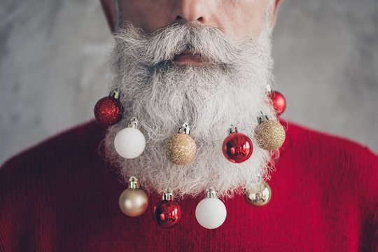 Closeup cropped photo of old serious santa claus man colorful toy balls in long beard x-mas decorations wear red pullover hipster outfit isolated grey color wall background