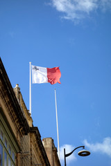 Flag of Malta, vertical bicolor of white and red with the representation of the George Cross edged in red on the upper hoist-side corner of the white band