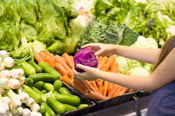 Female hand choosing vegetables in supermarket. Concept of healthy food, bio, vegetarian, diet.