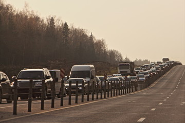 Obraz premium Traffic jam - a many cars on the highway on a autumn day at rush hour, delay
