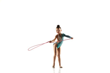 Little flexible girl isolated on white studio background. Little female model as a rhythmic...