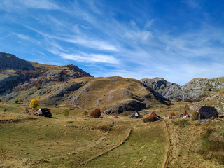Old traditional houses rooftops showing on a distant small village in the mountains with breathtaking mountain landscape and preserved nature