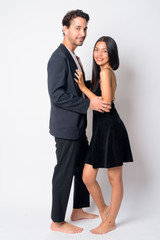 Full body shot of happy multi ethnic business couple embracing together