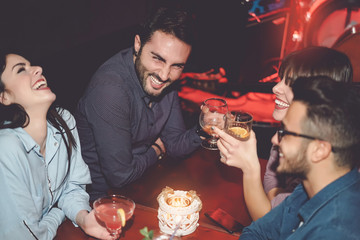Happy friends having fun in cocktail jazz bar - Young millennial people drinking ad laughing...