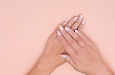 Beautiful stylish female manicure on a pink background.