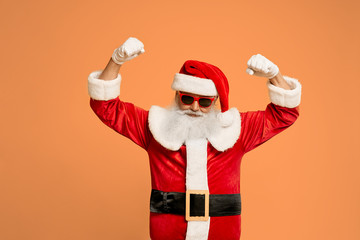 Fototapeta na wymiar Santa Claus in sunglasses holding hands in fists above head