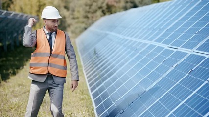 smiling businessman dancing near solar panels 