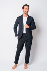 Full body shot of happy Hispanic businessman thinking