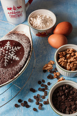 Brownie for Christmas and winter holidays. Homemade chocolate fudge brownie with ingredients and blue background. Merry Christmas.
