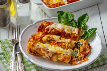 Spinach and ricotta stuffed cannelloni baked  in tomato sauce.