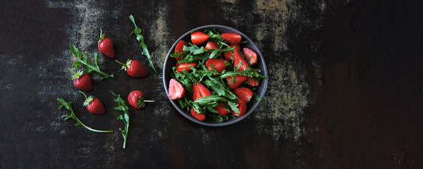 Fototapeta na wymiar Healthy bright arugula salad strawberry. Vegan Salad.