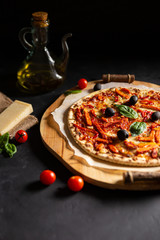 chicken tomato pepper pizza with olives and basil; vertical