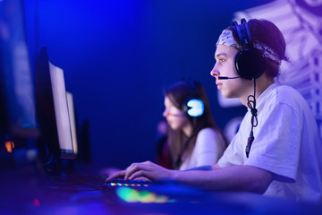 Team professional gamer playing tournaments online games computer with headphones, red and blue
