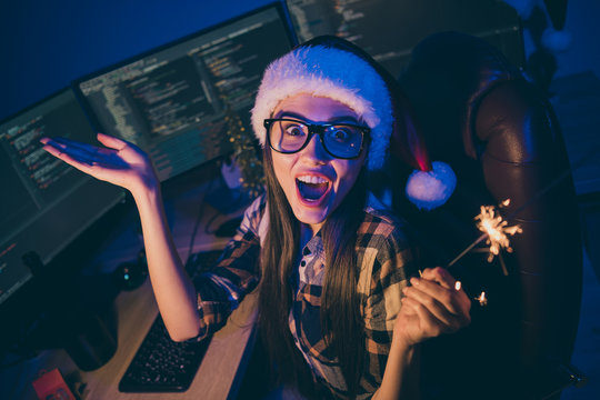Photo of it specialist lady holding sparkling fireworks at corporate company newyear party spending midnight night working wear santa cap glasses office indoors - Powered by Adobe