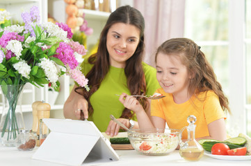 Cute little girl with her mother cooking together