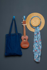 ukulele, denim bag, straw hat on the background.