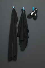 uniform for classical dance and ballet hanging on a gray background.