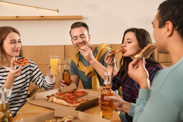 Group of friends having fun party with delicious pizza in cafe