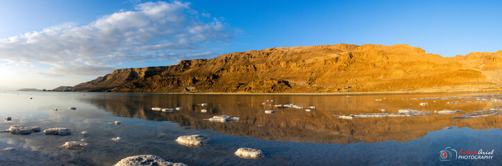 Dead Sea panorama at sunrise with salt rocks