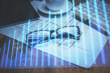 Financial chart hologram with glasses on the table background. Concept of business. Double exposure.