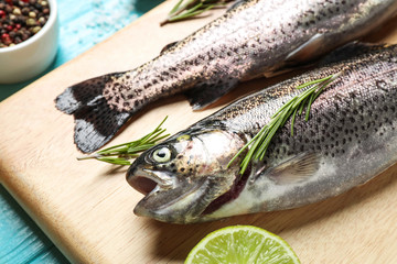 Raw cutthroat trout fish on wooden board, closeup