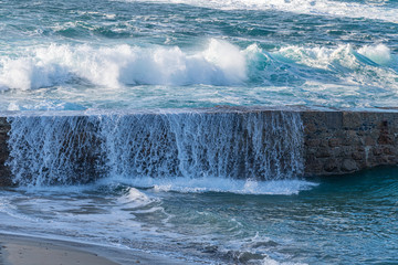 A curtain of water falling over the harbour wall, Sennen